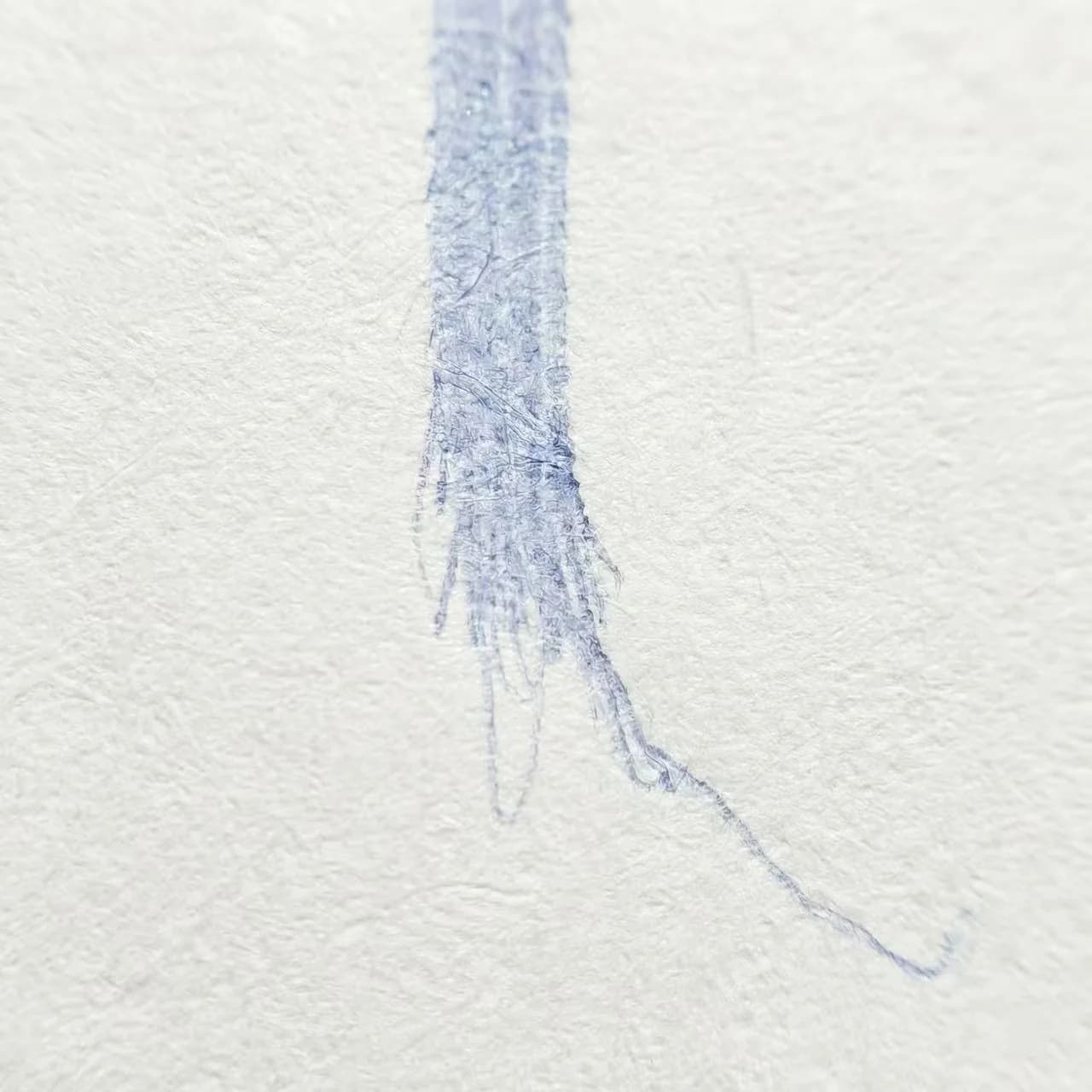 Macro photography of ballpoint pen stroke showing messy, tapered tail (overshoot)