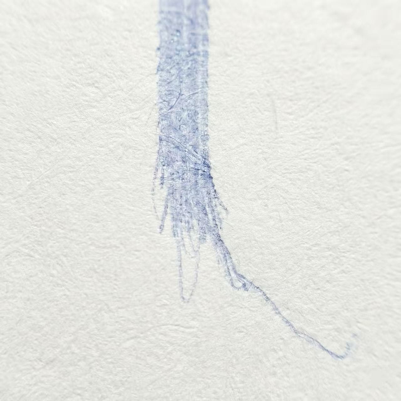Macro photography of ballpoint pen stroke showing messy, tapered tail (overshoot)